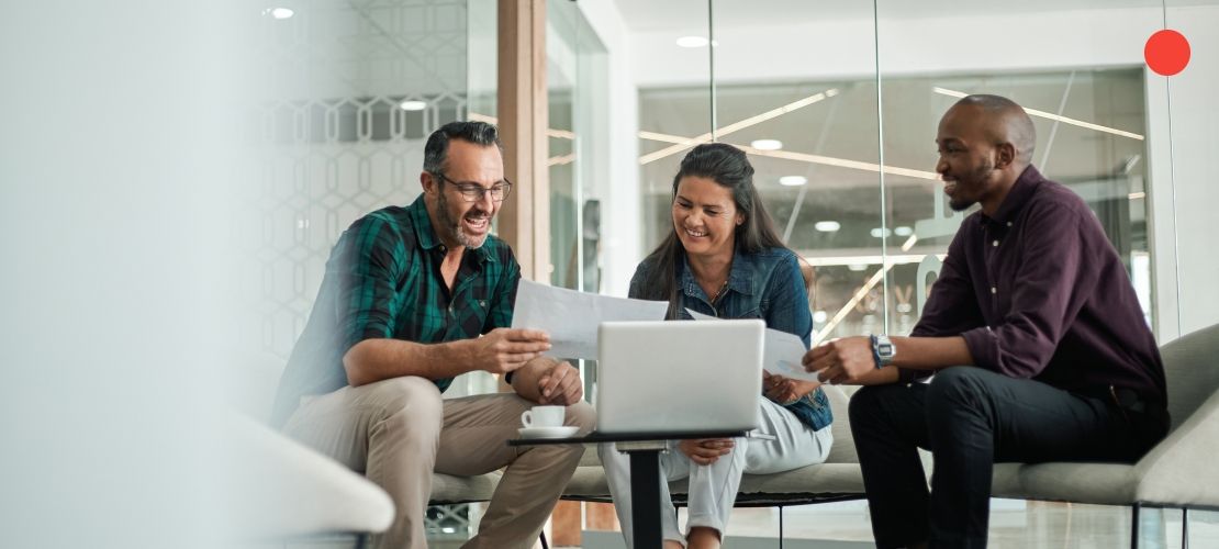 Dos hombres y una mujer en una sala de reuniones hablando